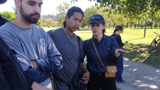 Two men and a woman look at something outside of the frame